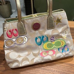 Fun Coach patterned bag with colorful horseshoes on front. Tan and gold